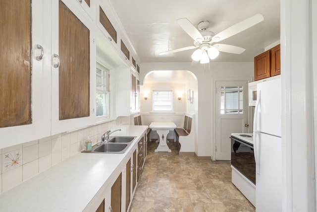 530 W Gordon Ave Unit 013, Spokane, WA 99205 - kitchen with white appliances, brown cabinetry, light countertops, arched walkways, and ceiling fan