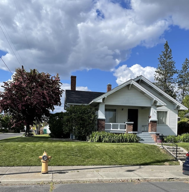 530 W Gordon Ave Unit 013, Spokane, WA 99205 - view of front facade featuring a chimney, a porch, a front lawn, and brick siding