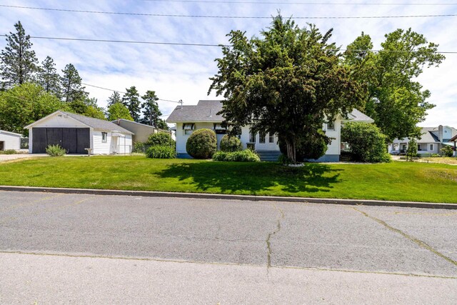 530 W Gordon Ave Unit 013, Spokane, WA 99205 - view of property hidden behind natural elements featuring a detached garage, a front yard, and an outbuilding