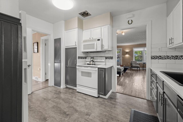 824 E E 38th Ave, Spokane, WA 99203 - kitchen with white appliances, light countertops, decorative backsplash, and white cabinets
