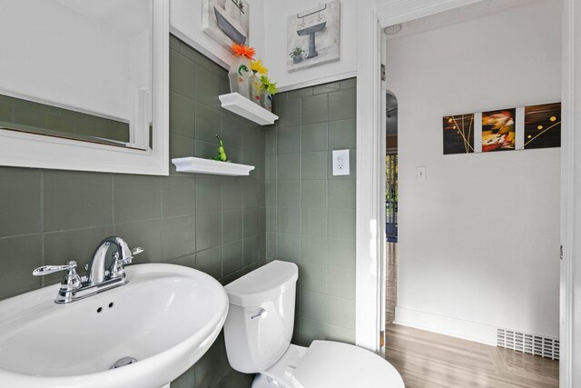 824 E E 38th Ave, Spokane, WA 99203 - bathroom featuring tile walls, wood finished floors, and tasteful backsplash