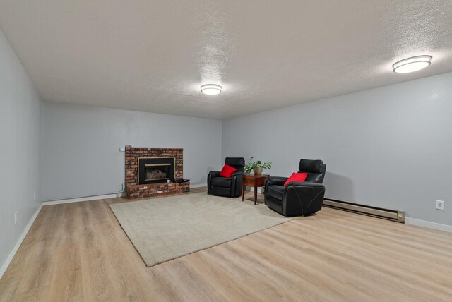 11628 N Galahad Dr, Spokane, WA 99218 - living area featuring a baseboard heating unit, wood finished floors, a textured ceiling, and a fireplace