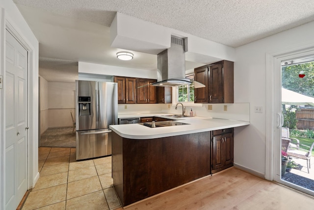11628 N Galahad Dr, Spokane, WA 99218 - kitchen featuring appliances with stainless steel finishes, island range hood, a peninsula, light countertops, and dark brown cabinetry