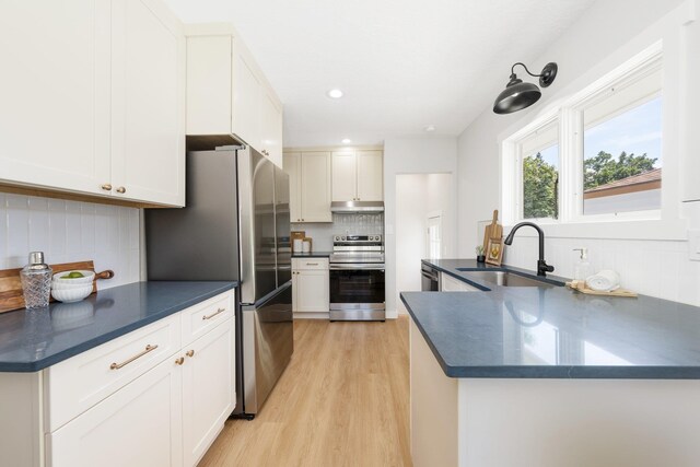 2917 W Dalton Ave, Spokane, WA 99205 - kitchen with appliances with stainless steel finishes, dark countertops, under cabinet range hood, tasteful backsplash, and recessed lighting