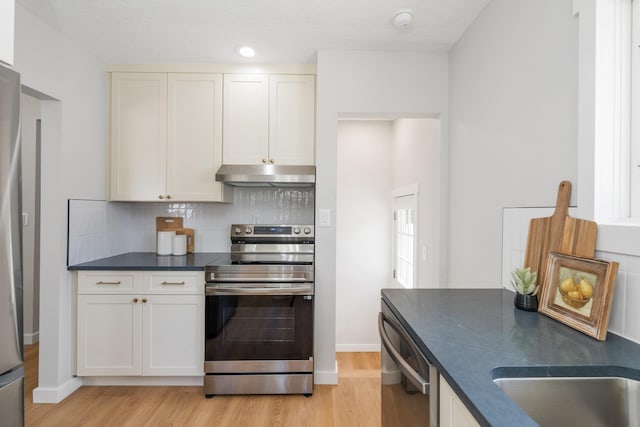 2917 W Dalton Ave, Spokane, WA 99205 - kitchen featuring stainless steel range with electric cooktop, under cabinet range hood, dark countertops, dishwashing machine, and light wood-type flooring