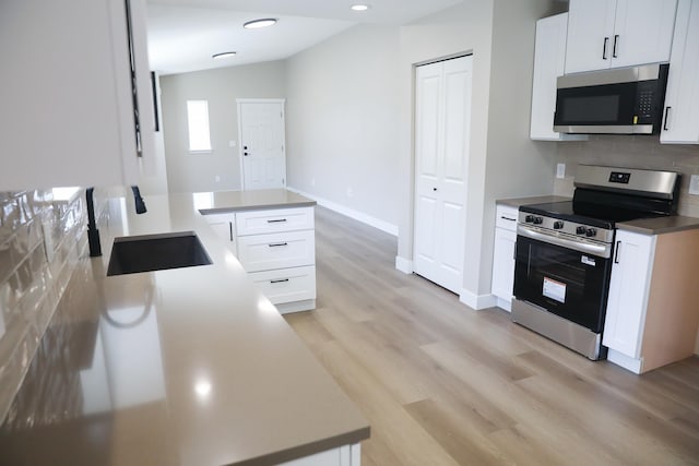 315 E I St, Deer Park, WA 99006 - kitchen with appliances with stainless steel finishes, backsplash, light wood-style flooring, white cabinetry, and recessed lighting