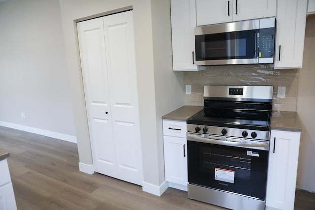 315 E I St, Deer Park, WA 99006 - kitchen with appliances with stainless steel finishes, wood finished floors, tasteful backsplash, and white cabinetry