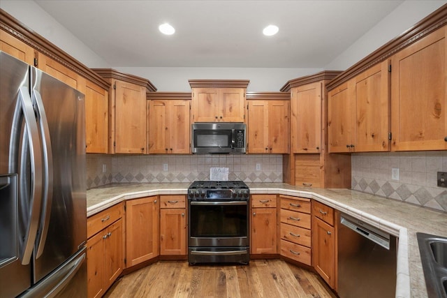 404 W Trail Ridge Ct, Spokane, WA 99224 - kitchen featuring stainless steel appliances, light wood-type flooring, tasteful backsplash, brown cabinetry, and recessed lighting