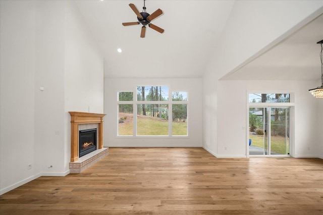404 W Trail Ridge Ct, Spokane, WA 99224 - unfurnished living room with a glass covered fireplace, high vaulted ceiling, plenty of natural light, a ceiling fan, and light wood-style floors