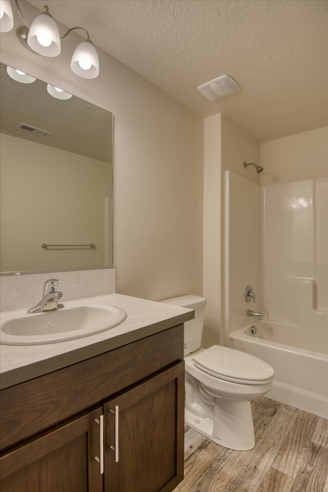 8115 W 57th Ave, Spokane, WA 99224 - bathroom featuring vanity, wood finished floors, a textured ceiling, and bathtub / shower combination