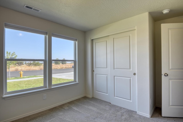 8115 W 57th Ave, Spokane, WA 99224 - unfurnished bedroom with carpet, multiple windows, a closet, and a textured ceiling