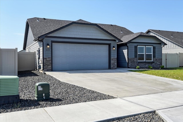 8115 W 57th Ave, Spokane, WA 99224 - view of front of property featuring an attached garage, stone siding, driveway, and a shingled roof