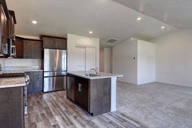 8115 W 57th Ave, Spokane, WA 99224 - kitchen with appliances with stainless steel finishes, dark brown cabinets, an island with sink, recessed lighting, and wood finished floors