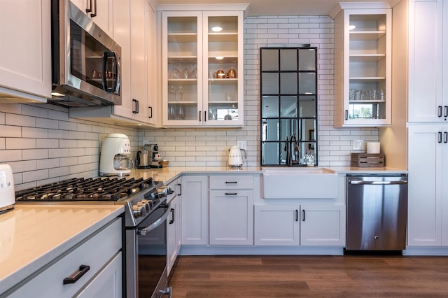 115 E Lake St Unit 203, Sandpoint, ID 83864 - kitchen with stainless steel appliances, light countertops, backsplash, and glass insert cabinets