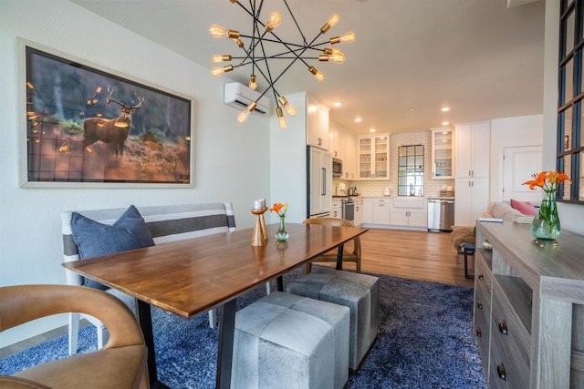 115 E Lake St Unit 203, Sandpoint, ID 83864 - dining room with wood finished floors, a wall mounted air conditioner, recessed lighting, and a chandelier