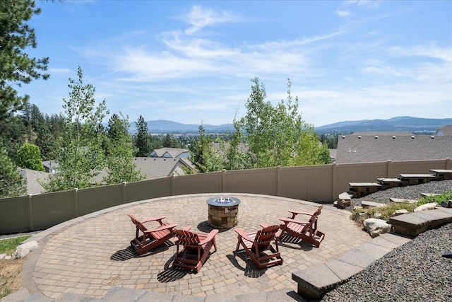 7620 E Ruby Ln, Spokane, WA 99212 - fenced backyard featuring a fire pit, a mountain view, and a patio