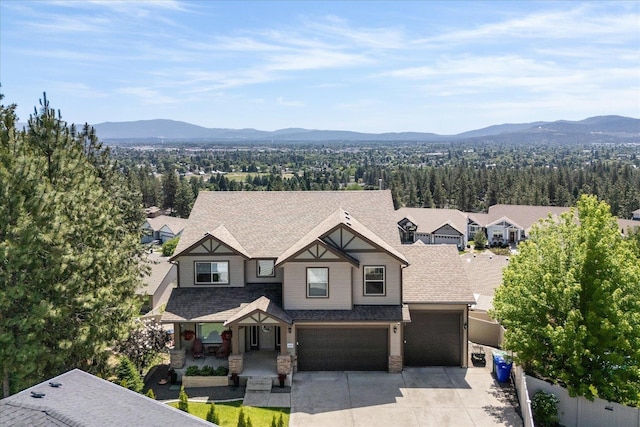 7620 E Ruby Ln, Spokane, WA 99212 - view of front of house with a mountain view, concrete driveway, stone siding, and a garage