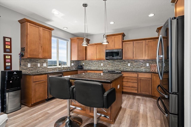 7620 E Ruby Ln, Spokane, WA 99212 - kitchen with stainless steel appliances, brown cabinets, light wood finished floors, tasteful backsplash, and recessed lighting
