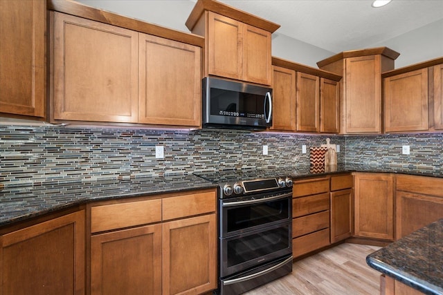 7620 E Ruby Ln, Spokane, WA 99212 - kitchen featuring stainless steel appliances, light wood finished floors, and dark stone counters