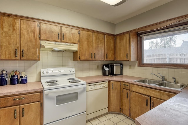 5022 W Garden Springs Ave Unit 5024W, Garden Springs, Spokane, WA 99224 - kitchen featuring white appliances, under cabinet range hood, decorative backsplash, brown cabinetry, and light countertops