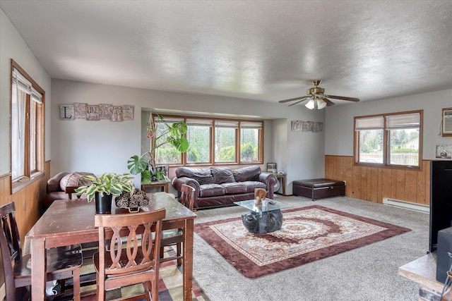 5022 W Garden Springs Ave Unit 5024W, Garden Springs, Spokane, WA 99224 - living room featuring wood walls, wainscoting, carpet flooring, ceiling fan, and a baseboard heating unit