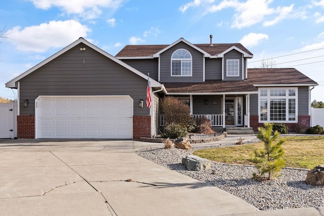 14706 N Mckinnon Ct, Mead, WA 99021 - traditional-style house featuring brick siding, a porch, concrete driveway, and an attached garage