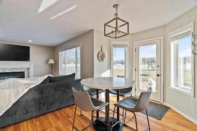 14706 N Mckinnon Ct, Mead, WA 99021 - dining room featuring light wood-style floors, a fireplace, a chandelier, and a textured ceiling