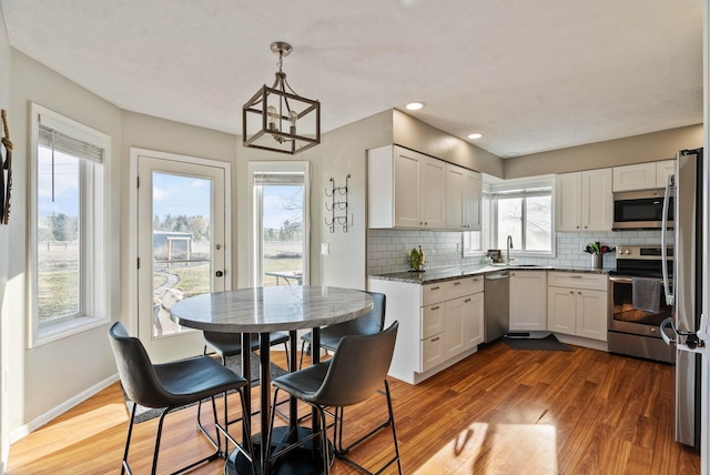 14706 N Mckinnon Ct, Mead, WA 99021 - kitchen featuring stainless steel appliances, tasteful backsplash, dark wood-style floors, and recessed lighting