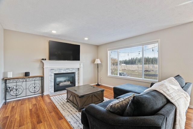 14706 N Mckinnon Ct, Mead, WA 99021 - living area with wood finished floors, recessed lighting, a stone fireplace, and a textured ceiling