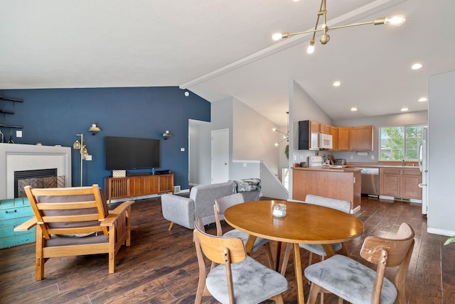 724 E Joshua Dr, Medical Lake, WA 99022 - dining space with dark wood-style flooring, lofted ceiling, a chandelier, and a glass covered fireplace