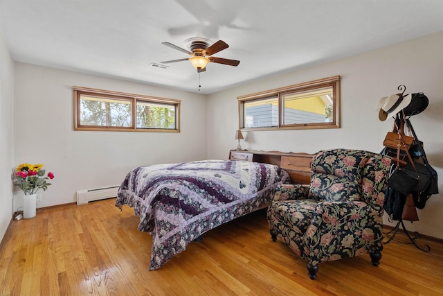 3205 W Hoffman Ave, Spokane, WA 99205 - bedroom featuring a baseboard heating unit, light wood-style flooring, and a ceiling fan