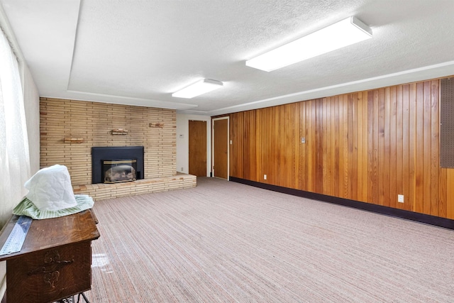 3205 W Hoffman Ave, Spokane, WA 99205 - unfurnished living room with a fireplace, a textured ceiling, carpet floors, and wood walls