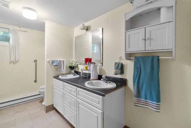 3205 W Hoffman Ave, Spokane, WA 99205 - bathroom with baseboard heating, double vanity, tile patterned floors, and a shower