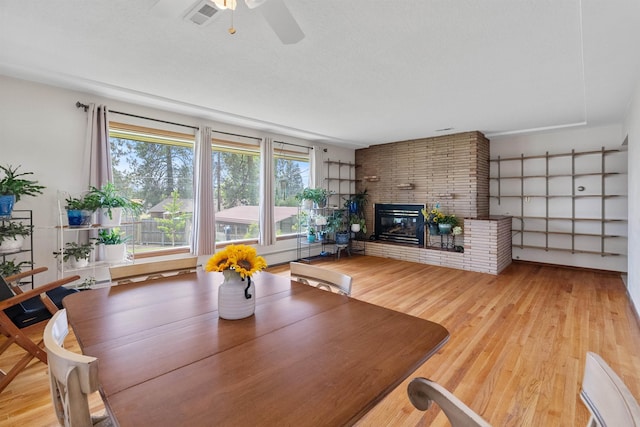 3205 W Hoffman Ave, Spokane, WA 99205 - dining area featuring a brick fireplace, wood finished floors, and a ceiling fan