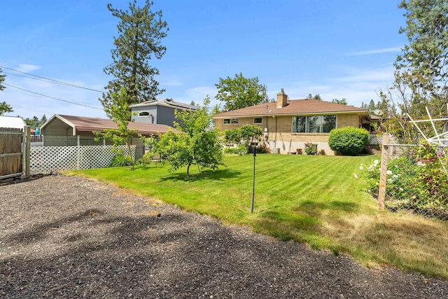 3205 W Hoffman Ave, Spokane, WA 99205 - rear view of house featuring a carport, a chimney, and gravel driveway