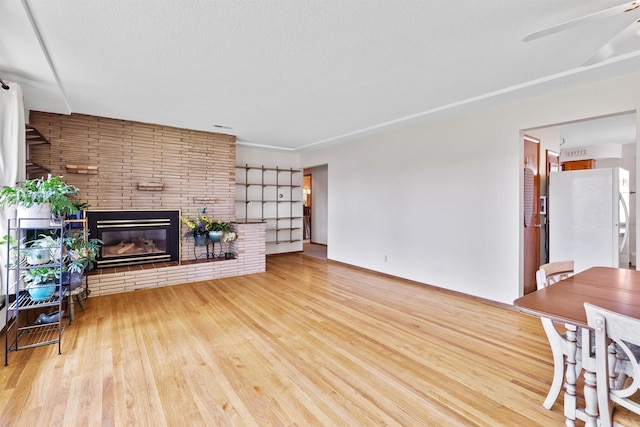 3205 W Hoffman Ave, Spokane, WA 99205 - living area featuring wood finished floors, a fireplace, and a ceiling fan