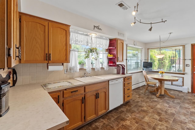 3205 W Hoffman Ave, Spokane, WA 99205 - kitchen with dishwasher, light countertops, backsplash, and brown cabinets