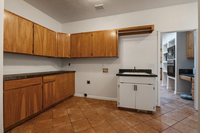 16417 N Napa Ln, Spokane, WA 99208 - laundry area with hookup for a washing machine, cabinet space, hookup for an electric dryer, and tile patterned flooring