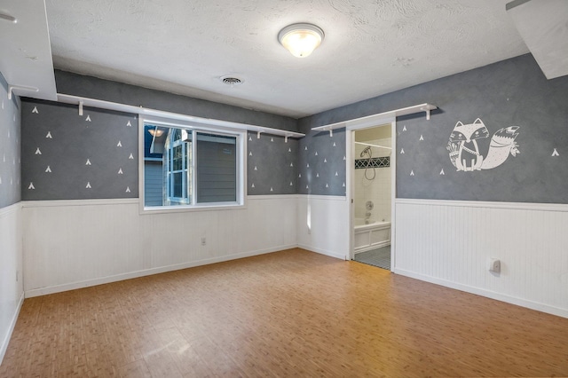 16417 N Napa Ln, Spokane, WA 99208 - empty room featuring wood finished floors, wainscoting, and a textured ceiling