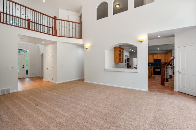 16417 N Napa Ln, Spokane, WA 99208 - unfurnished living room with light colored carpet, a high ceiling, recessed lighting, stairs, and arched walkways