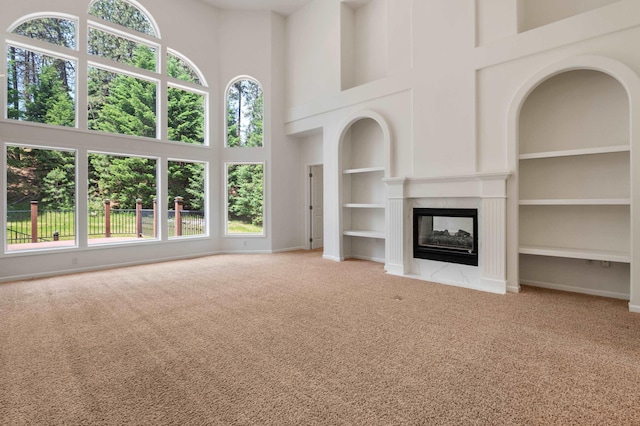 16417 N Napa Ln, Spokane, WA 99208 - unfurnished living room with a towering ceiling, carpet flooring, built in shelves, and a multi sided fireplace