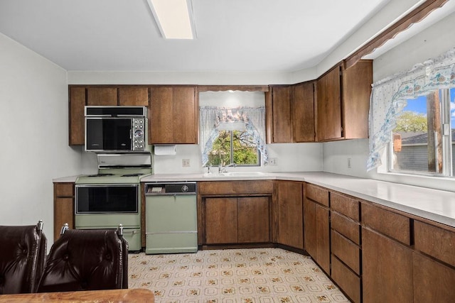 2920 N Regal St, Spokane, WA 99207 - kitchen with white range, black microwave, light countertops, and healthy amount of natural light