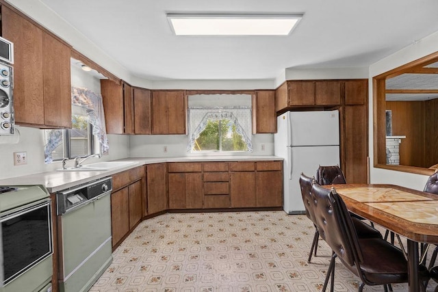 2920 N Regal St, Spokane, WA 99207 - kitchen featuring white appliances, light countertops, brown cabinetry, and light floors