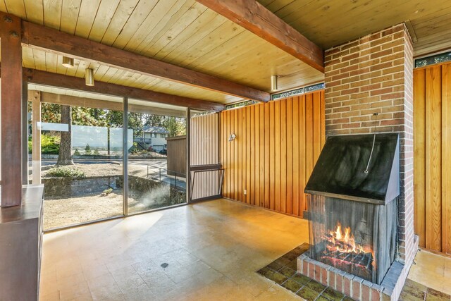 3717 E 17th Ave, Spokane, WA 99223 - unfurnished living room with a fireplace, a wood ceiling with exposed beams, wooden walls, and tile patterned floors