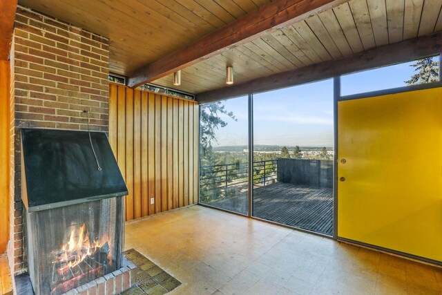 3717 E 17th Ave, Spokane, WA 99223 - unfurnished living room featuring a fireplace, tile patterned floors, expansive windows, and a wooden ceiling with exposed beams