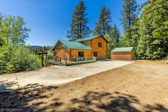 32261 N Leclerc Rd, Ione, WA 99139 - view of side of property featuring log exterior, an outbuilding, a deck, a metal roof, and concrete driveway
