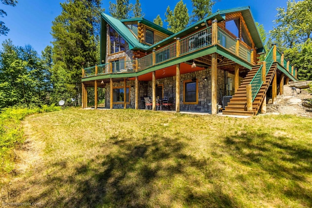 32261 N Leclerc Rd, Ione, WA 99139 - rear view of house featuring a deck, log siding, a lawn, stairs, and stone siding