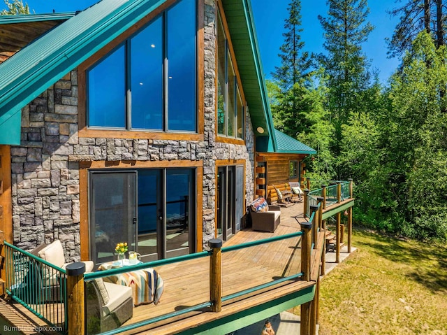 32261 N Leclerc Rd, Ione, WA 99139 - rear view of property featuring stone siding, a metal roof, a wooden deck, and a lawn