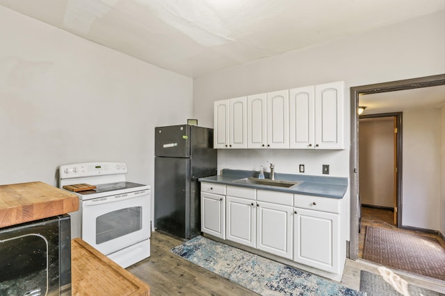524 W Montgomery Ave, Spokane, WA 99205 - kitchen with white electric range oven, freestanding refrigerator, wood finished floors, and white cabinetry