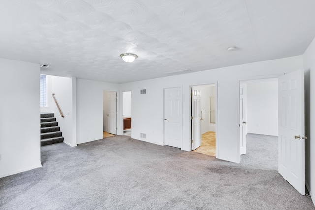 5019 W W Prosperity Ln, Spokane, WA 99208 - unfurnished bedroom with carpet floors, ensuite bathroom, and a textured ceiling